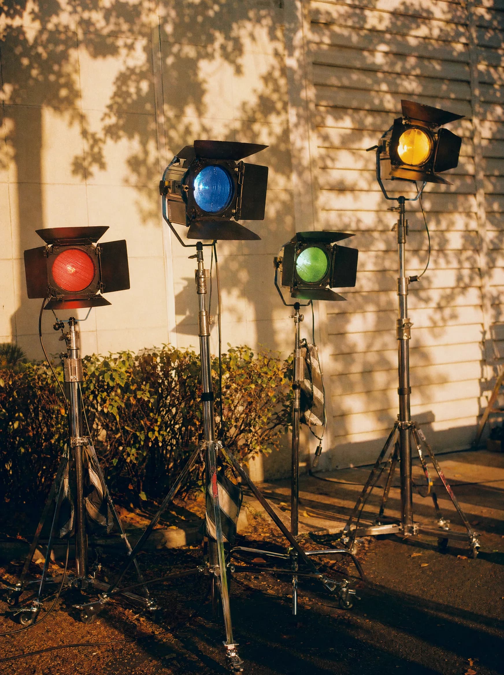 Coloured film-set lights on stands at golden hour